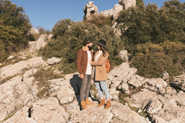 山の風景でポーズをとる若いカップル