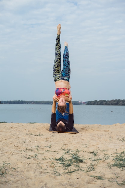 young couple practicing yoga on city background