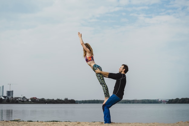 Giovane coppia praticare yoga sullo sfondo della città