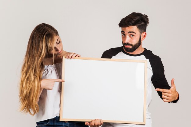 Young couple presenting board