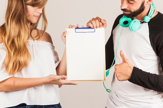 Young couple presenting clipboard