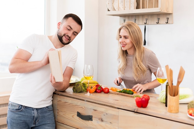 Young couple reading a book in the kitchen