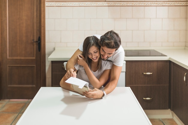 Young couple reading notebook together