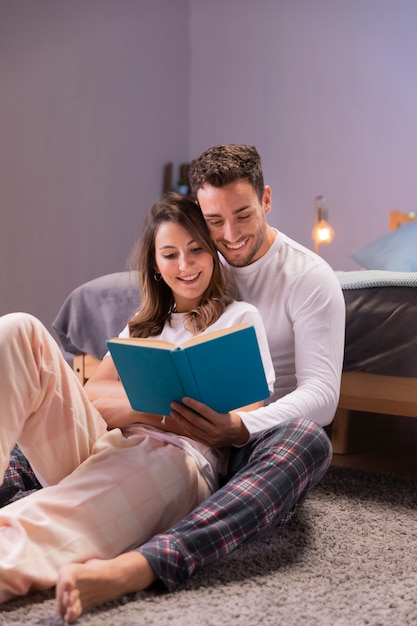 Молодая пара читает вместе в постели