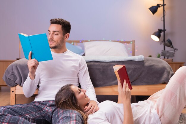 Young couple reading together in bed