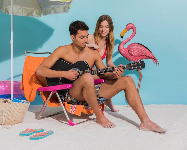 Young couple resting on beach in studio