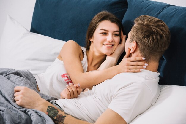 Young couple resting in light bed