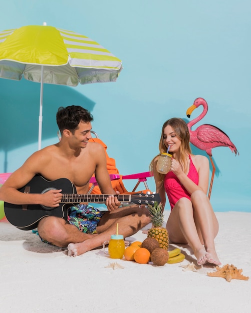 Free photo young couple resting on sand in studio