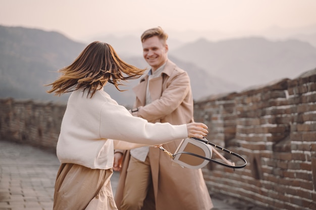 Бесплатное фото Молодая пара бегает и вертится у великой китайской стены