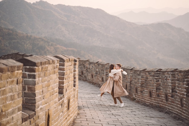 젊은 부부는 중국의 만리 장성에서 달리기와 달리기