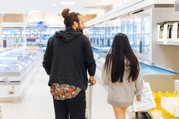 Молодая пара на покупки в супермаркете