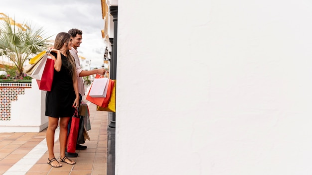 Free photo young couple shopping with copy space