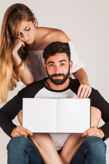Young couple showing blank book