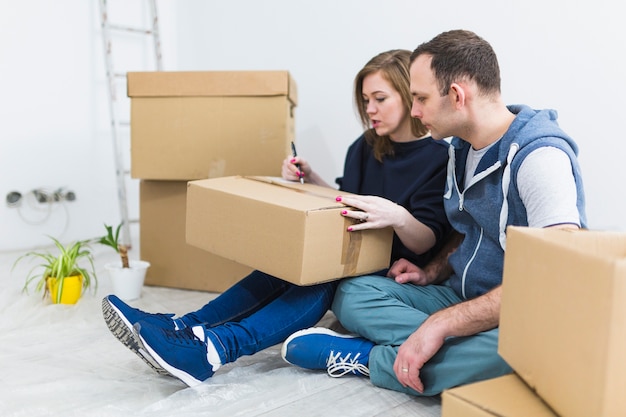 Young couple signing boxes