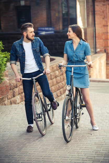 街の向かいの自転車に座っている若いカップル