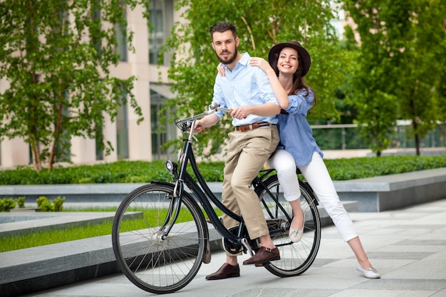 Молодая пара, сидящая на велосипеде
