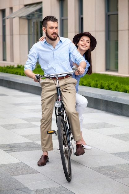 Free photo young couple sitting on a bicycle