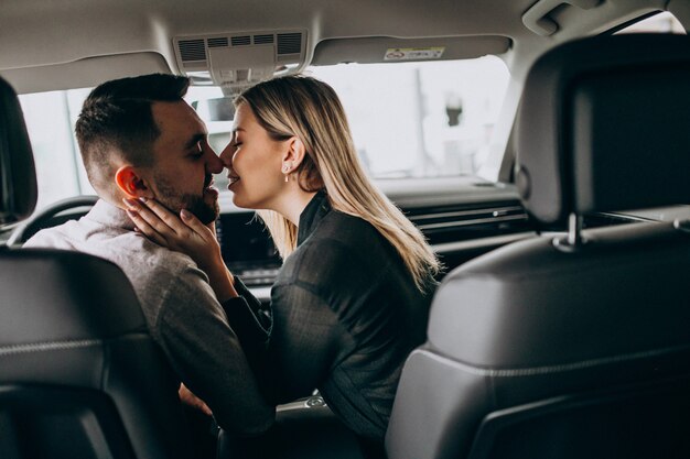 Молодая пара сидит в машине и целует