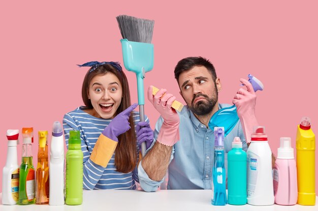 Young couple sitting next to cleaning products