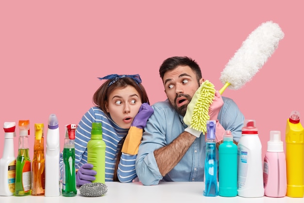 Young couple sitting next to cleaning products