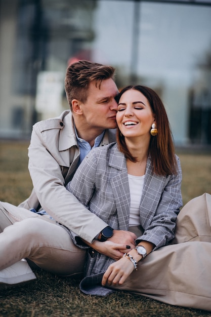 Young couple sitting on grass by the building