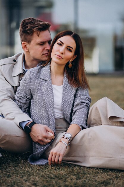 Young couple sitting on grass by the building