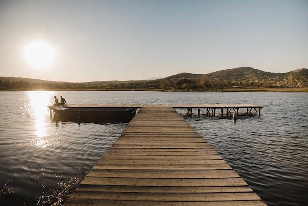 Free Stock Photos: Young Couple Sitting on Jetty