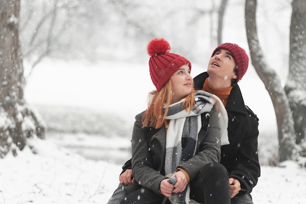 Young couple sitting and looking up