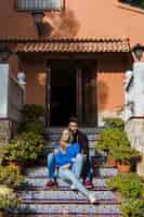 Free photo young couple sitting on porch