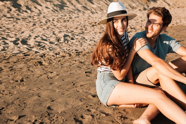 Young couple sitting on the sand