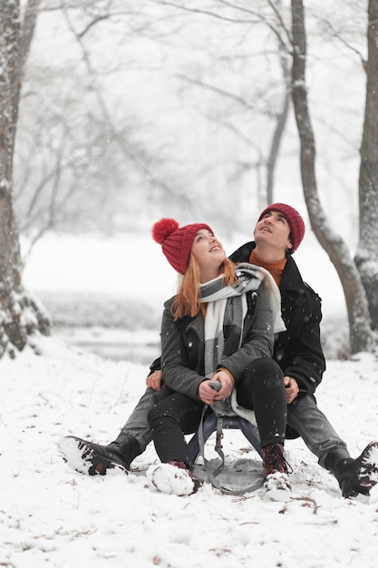 Young couple sitting on sleigh