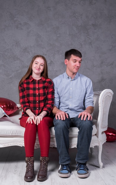 Free photo young couple sitting on sofa