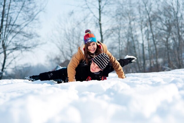 Young couple sledding on snow