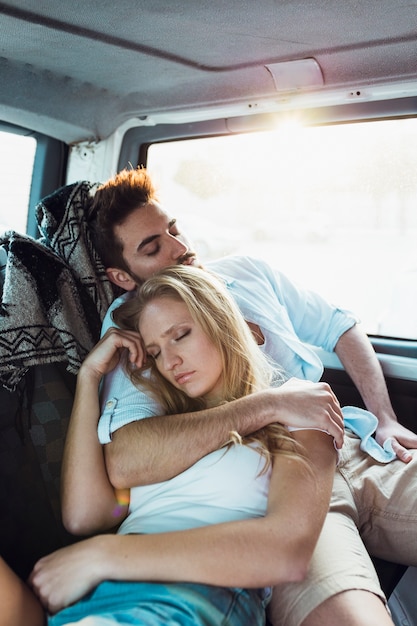 Young couple sleeping in car