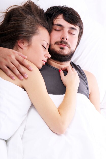 若いカップルがベッドで眠る