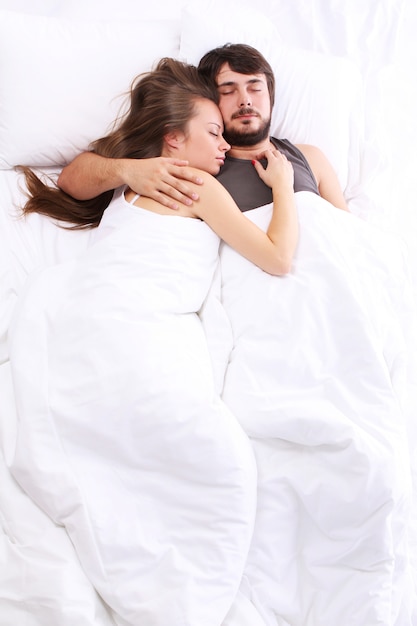 Young couple sleeps in bed