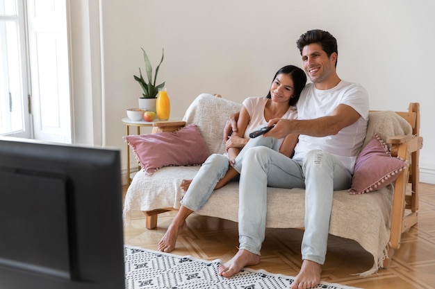 Молодая пара проводит время перед телевизором