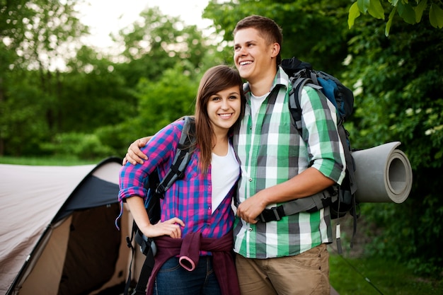 Young couple standing in front of tent