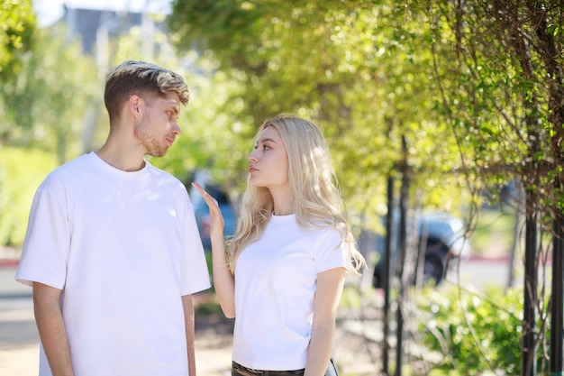 Free photo young couple standing on at the park and looking at each other