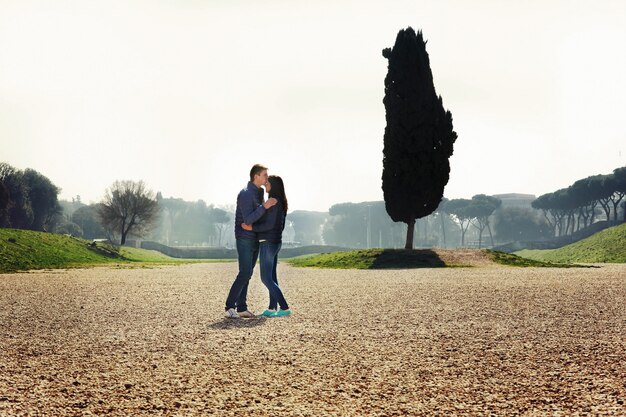 Young couple stands in green park in Rome