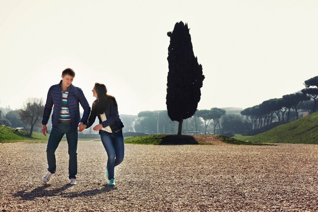 Young couple stands in green park in Rome