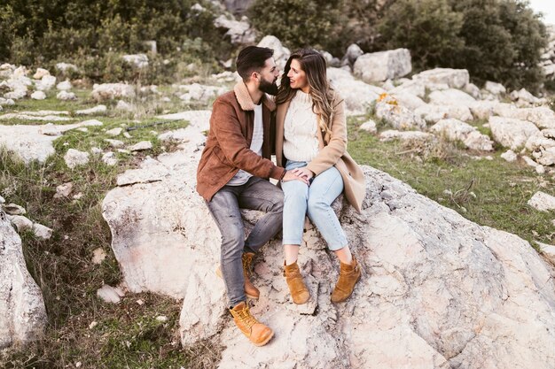 Young couple staying on a rock