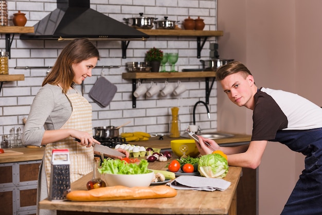 Young couple at table cooking in kitchen 