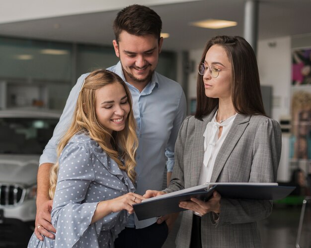 Young couple talking with a car dealer