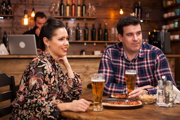 Young couple together having a great time. Delicious pizza.