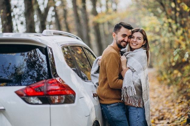 Young couple together in park by the car