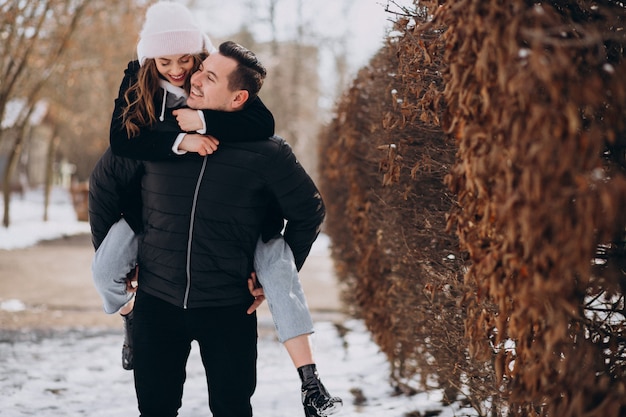 Young couple together in a winter park on valentines day