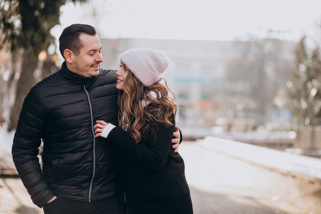 Young couple together in a wintery street on a valentines day