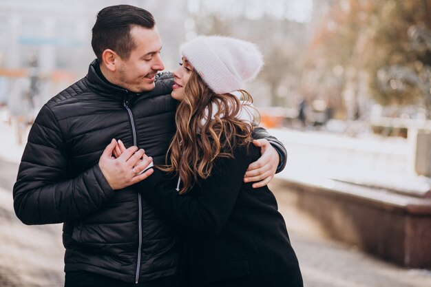 Young couple together in a wintery street on a valentines day