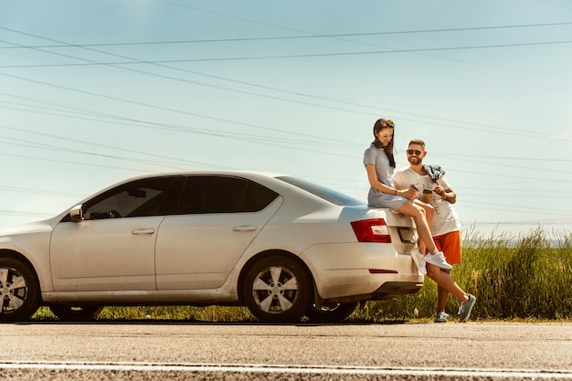 Young couple traveling on the car in sunny day